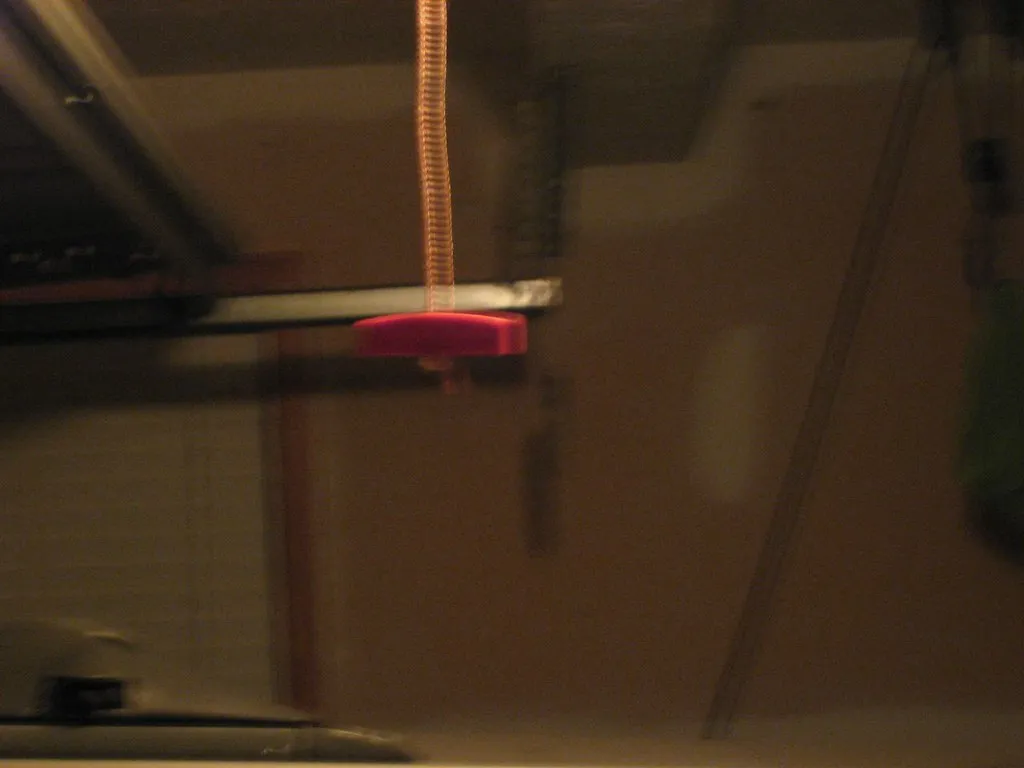 Red pull cord call point mounted beside a toilet in a hospital ensuite