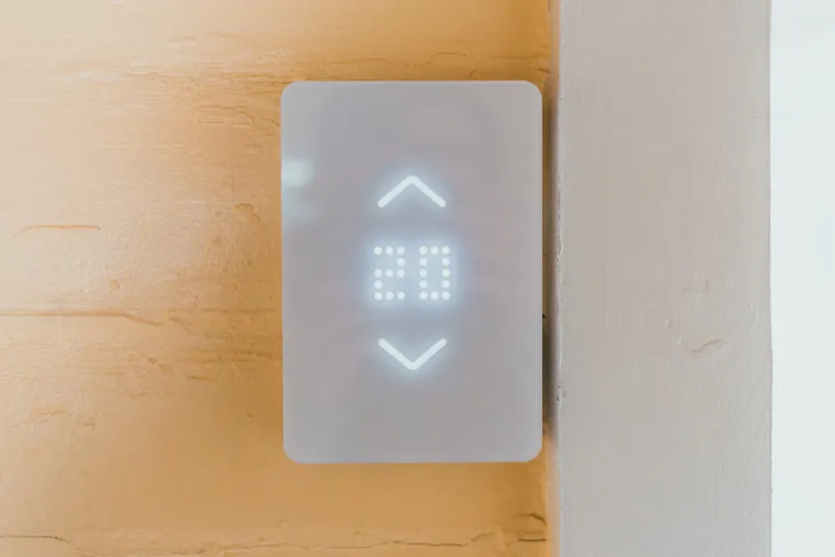 Wall-mounted call point beside the toilet in an aged care ensuite with grab rails