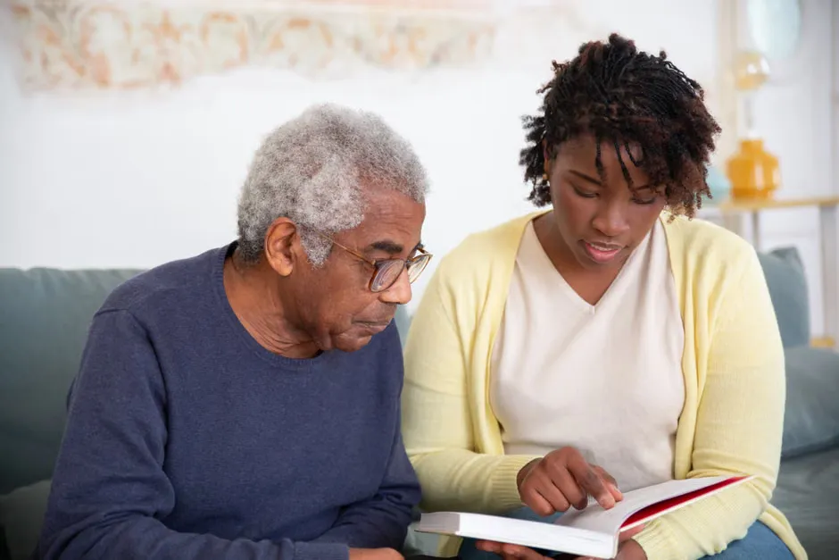 Caregiver reading a nurse call alert on a smartphone in a ward corridor