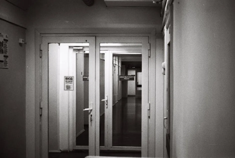 Hospital corridor at night with an illuminated overdoor call light outside a patient room