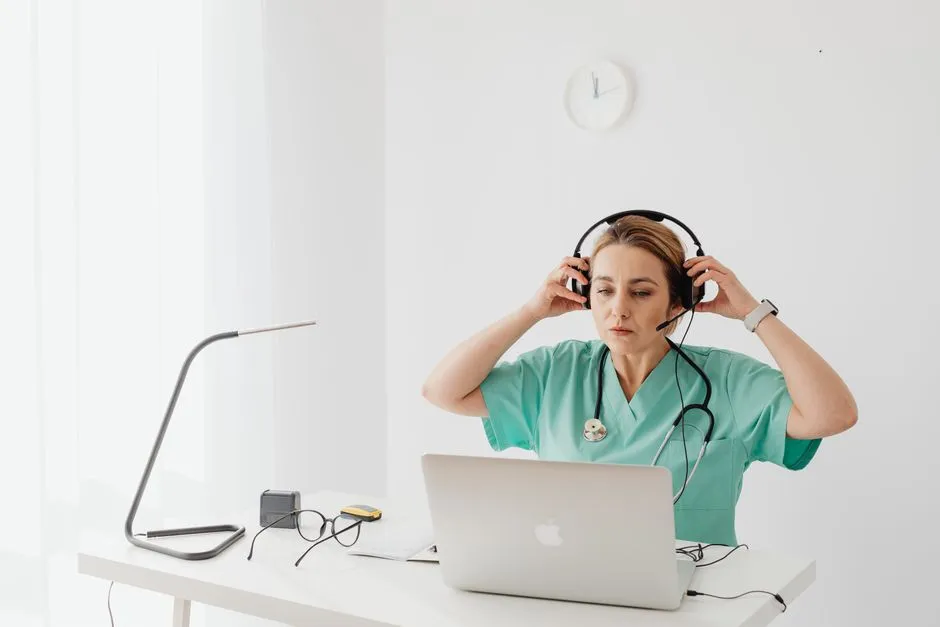 Portable nurse call receiver held by staff at a small clinic reception desk