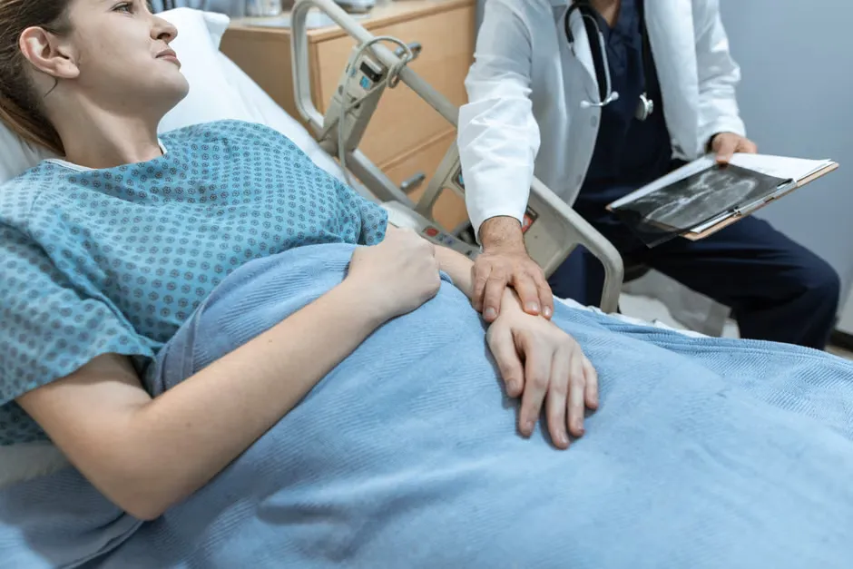 Patient bedside handset with call and light buttons resting on a hospital bed rail