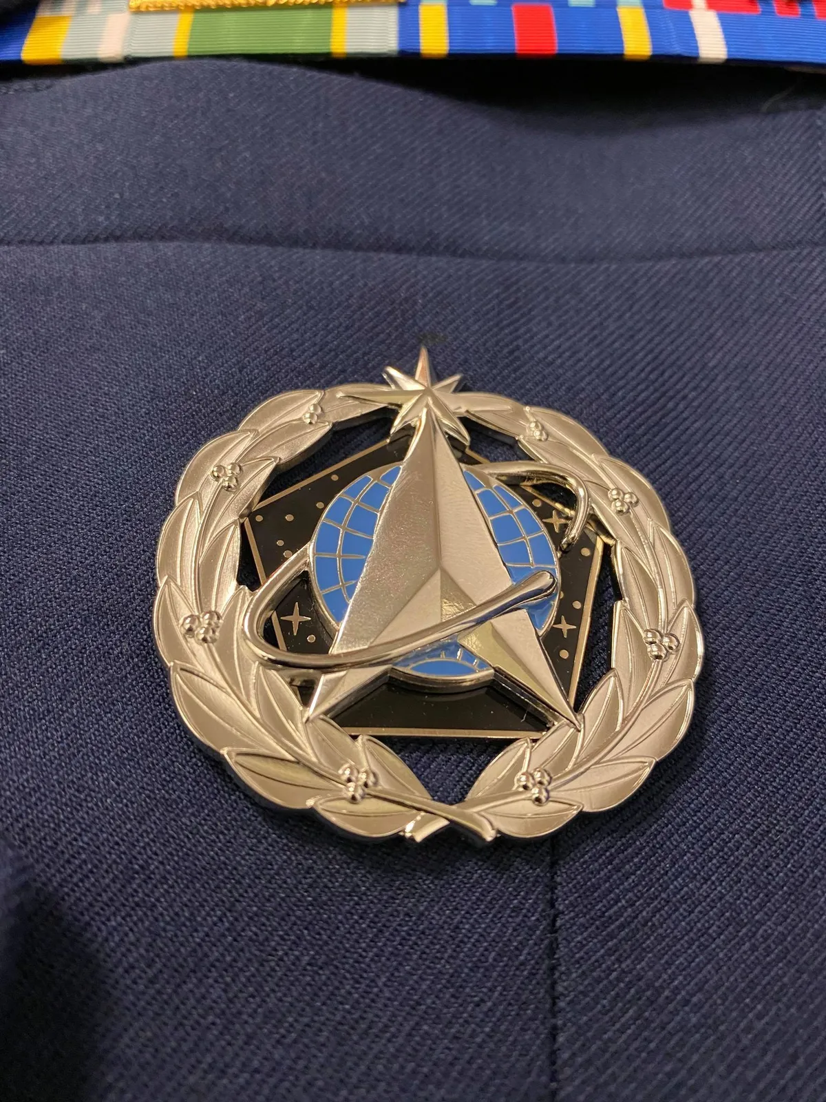 Staff location badge clipped to a nurse's uniform during a bedside check